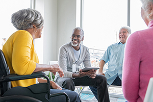 Group of seniors smiling and talking at group therapy sessions